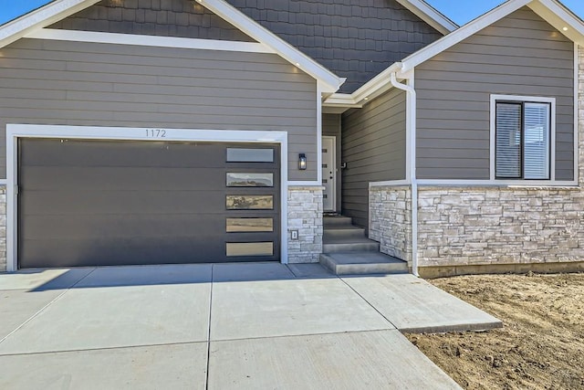 view of front of house with stone siding and concrete driveway