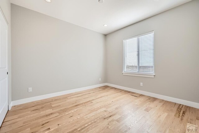 spare room featuring baseboards, recessed lighting, and light wood-style floors