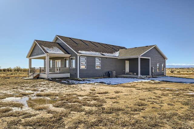 back of house with a porch and cooling unit