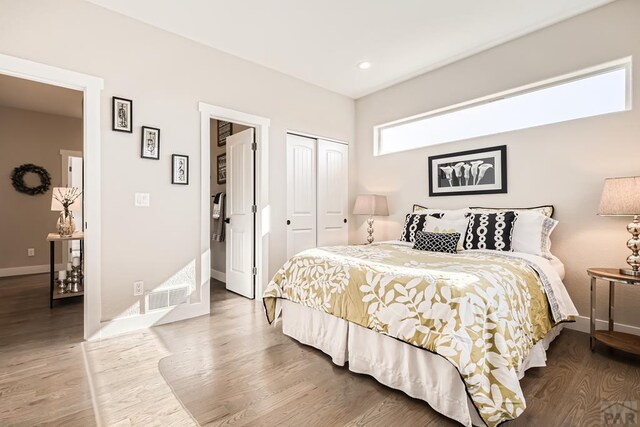 bedroom featuring baseboards, visible vents, and wood finished floors