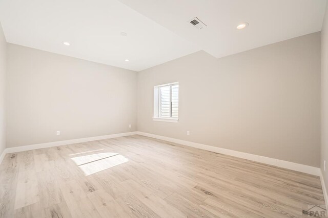 empty room featuring light wood-type flooring, baseboards, and recessed lighting