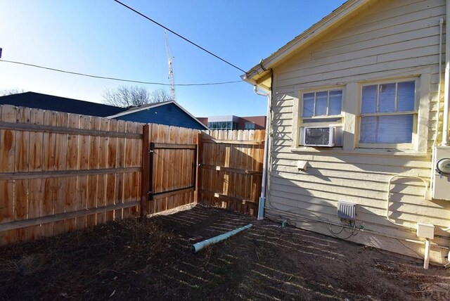 view of side of home with cooling unit and fence