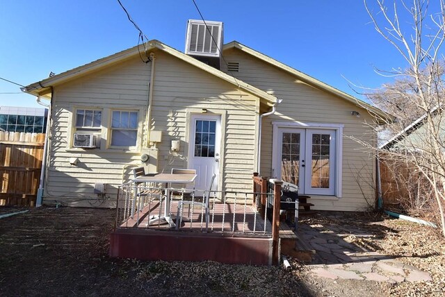 rear view of house featuring a deck, cooling unit, and fence