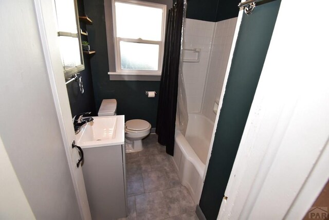 bathroom with baseboards, toilet, tile patterned floors, shower / bathtub combination with curtain, and vanity