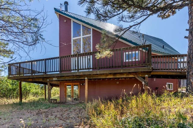 back of house with metal roof and a deck