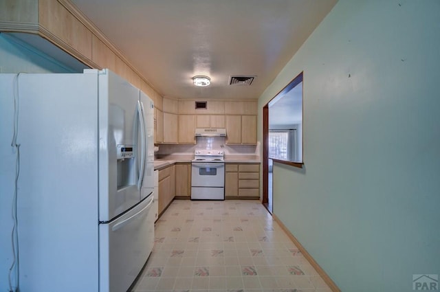 2621 Begonia St, Pueblo, CO 81005 - kitchen with white appliances, light brown cabinetry, visible vents, under cabinet range hood, and light countertops
