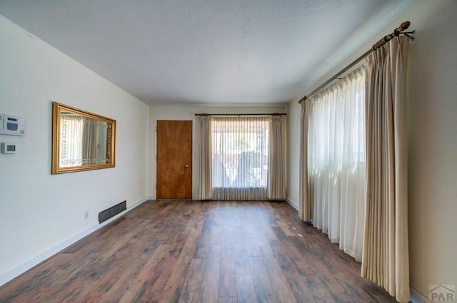 2621 Begonia St, Pueblo, CO 81005 - spare room featuring dark wood-type flooring, baseboards, and visible vents