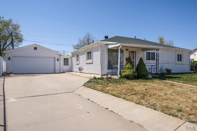 2621 Begonia St, Pueblo, CO 81005 - view of front of property with a garage, a front yard, driveway, and stucco siding