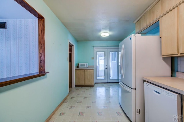 2621 Begonia St, Pueblo, CO 81005 - kitchen featuring white appliances, light countertops, french doors, light brown cabinets, and baseboards