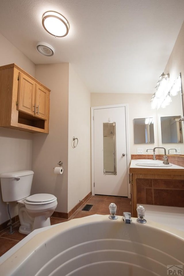 bathroom featuring toilet, visible vents, vanity, a bath, and tile patterned floors