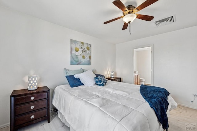 bedroom with visible vents, connected bathroom, light wood-type flooring, and ceiling fan