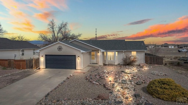 ranch-style house with a garage, stucco siding, driveway, and fence