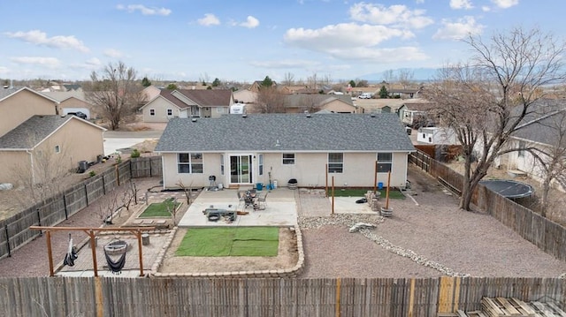 back of house featuring stucco siding, a patio, a residential view, and a fenced backyard