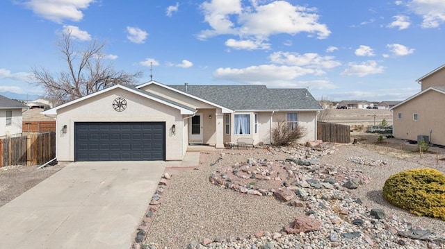 ranch-style house featuring fence, a garage, driveway, and stucco siding