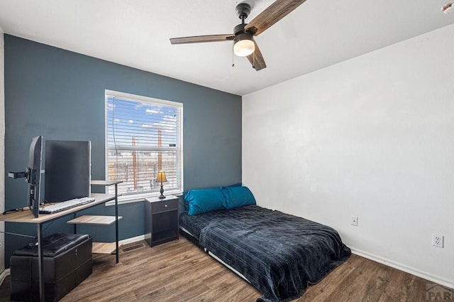 bedroom featuring a ceiling fan, wood finished floors, and baseboards