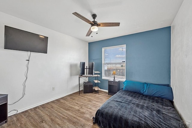 bedroom featuring a ceiling fan, wood finished floors, and baseboards