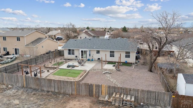 back of house featuring a residential view, stucco siding, a patio, and a fenced backyard