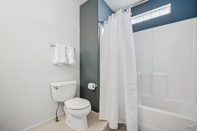 bathroom featuring tile patterned floors, baseboards, toilet, and shower / bath combo with shower curtain