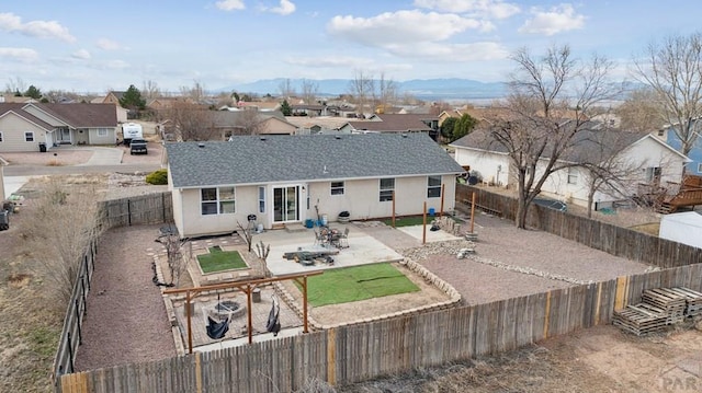 back of house with a residential view, stucco siding, a patio, and a fenced backyard