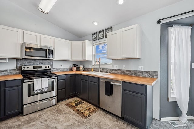 kitchen with gray cabinetry, stainless steel appliances, white cabinetry, wood counters, and a sink