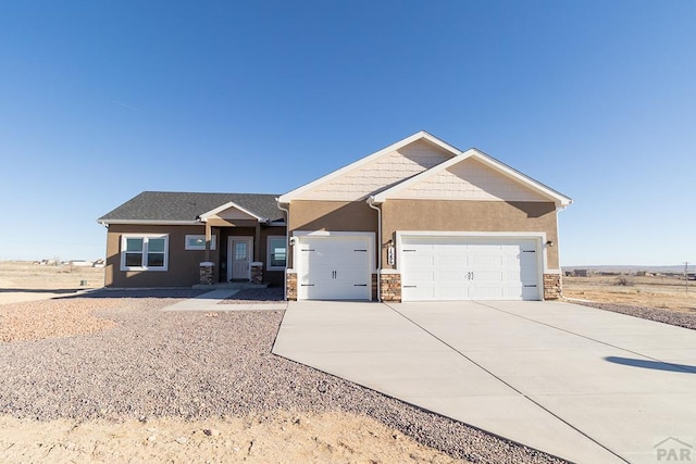 craftsman-style house with a garage, stone siding, driveway, and stucco siding