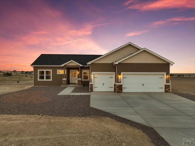 view of front facade featuring a garage, driveway, and stucco siding