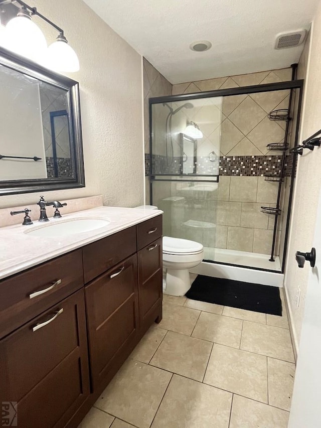 bathroom featuring toilet, vanity, visible vents, and tile patterned floors