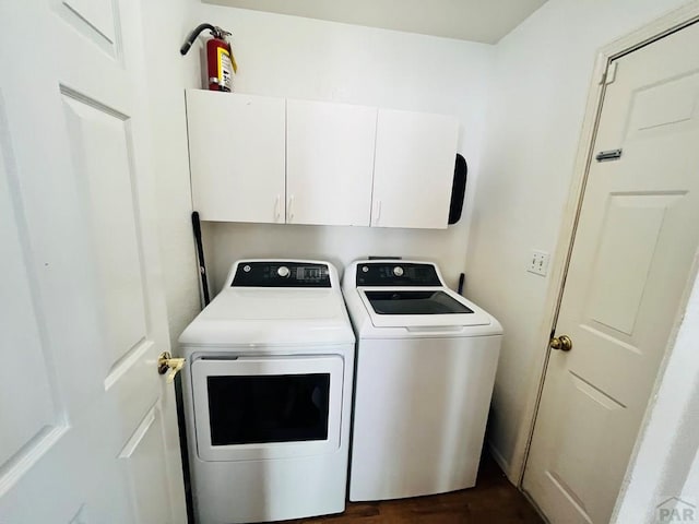 laundry room featuring dark wood-style flooring, independent washer and dryer, and cabinet space