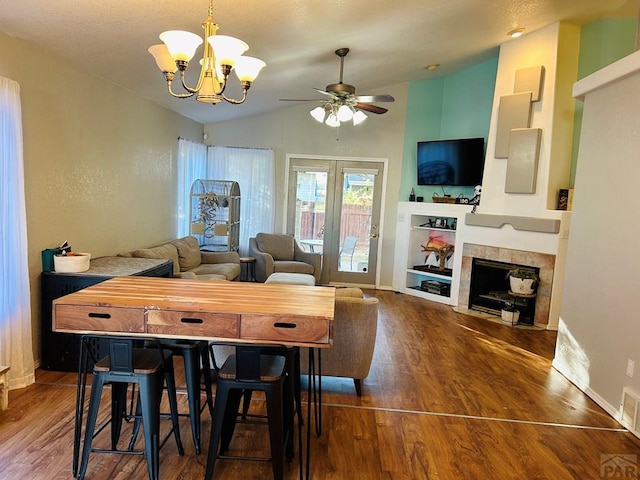 dining area with lofted ceiling, dark wood-style flooring, a fireplace, and baseboards