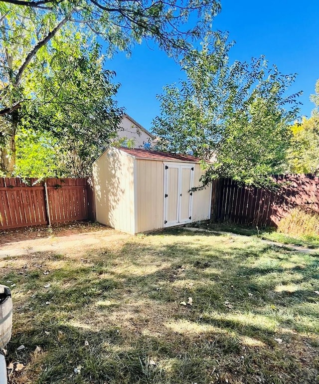 view of yard with a storage shed, an outdoor structure, and a fenced backyard