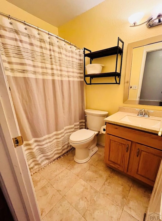 bathroom with toilet, tile patterned floors, and vanity