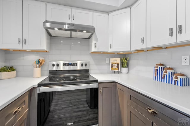 3666 Iguana Dr, Colorado Springs, CO 80910 - kitchen with stainless steel electric stove, under cabinet range hood, decorative backsplash, and light countertops