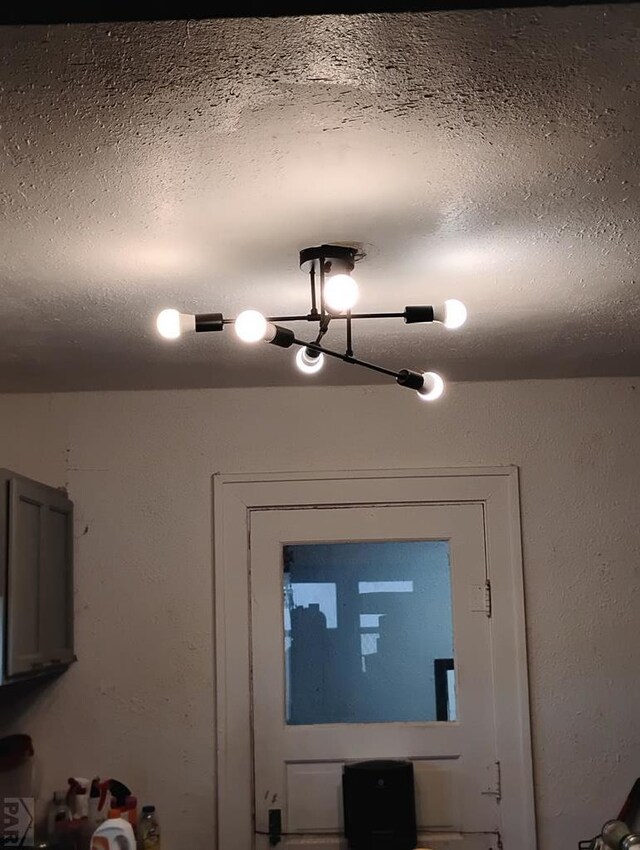 interior details featuring a textured ceiling and a textured wall