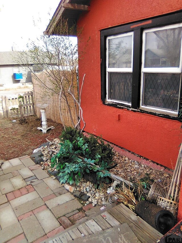 view of home's exterior with fence and stucco siding