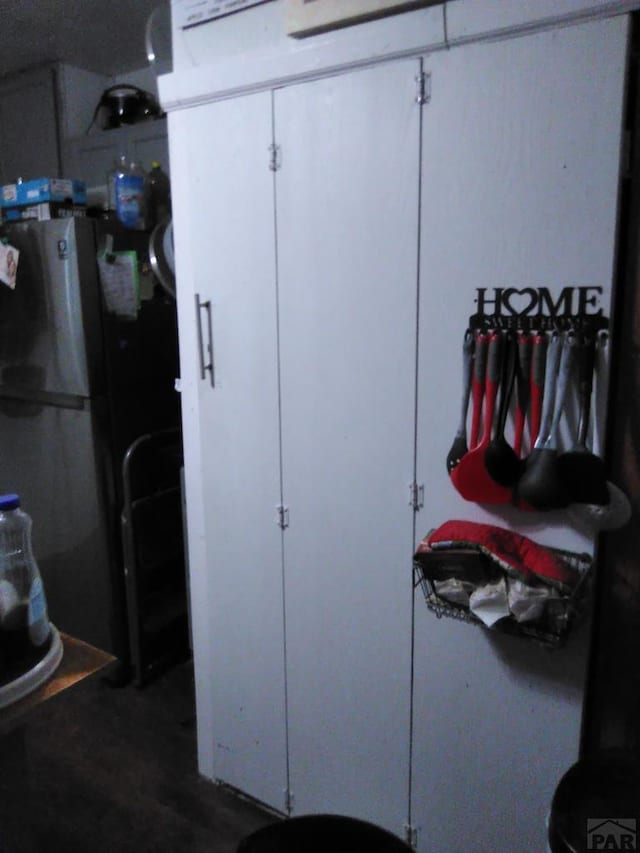 interior space featuring wood finished floors and freestanding refrigerator