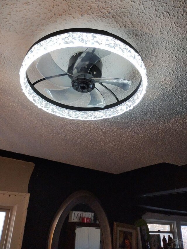 details with ceiling fan and a textured ceiling