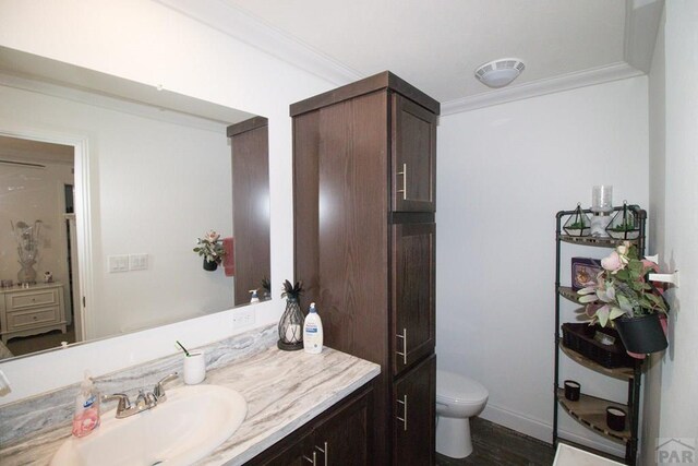 218 W Thurlow Ave, Cripple Creek, CO 80813 - bathroom featuring vanity, toilet, wood finished floors, crown molding, and baseboards