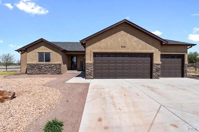ranch-style home featuring driveway, stone siding, stucco siding, and a garage