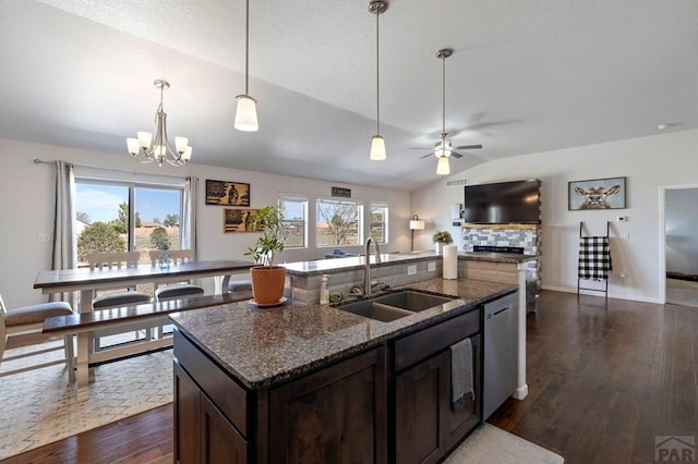 kitchen with dishwasher, a fireplace, a sink, open floor plan, and lofted ceiling
