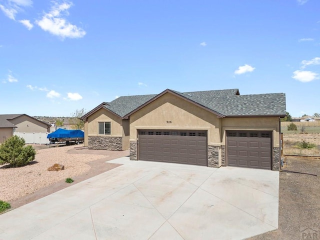 view of front of property featuring stucco siding, fence, a garage, stone siding, and concrete driveway