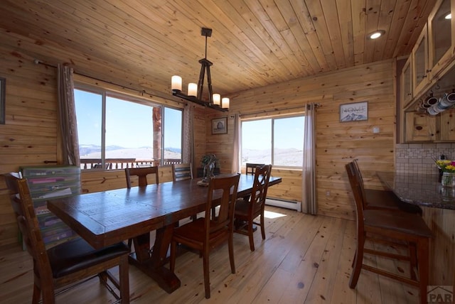 1160 Diamond Black Trl, Canon City, CO 81212 - dining room featuring light wood-style floors, a chandelier, wooden ceiling, a baseboard heating unit, and a healthy amount of sunlight