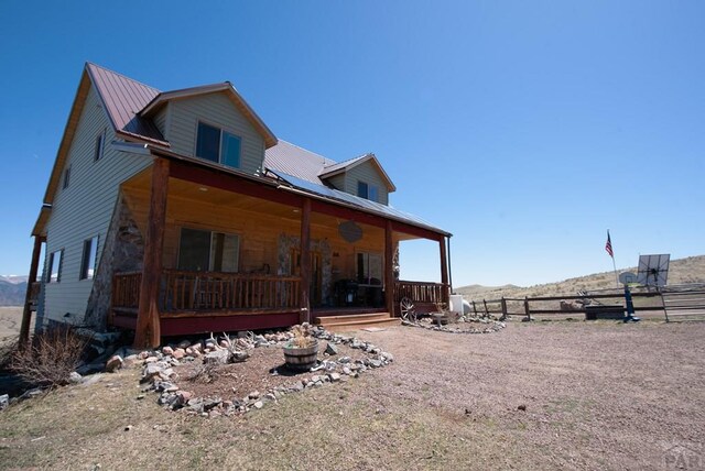 1160 Diamond Black Trl, Canon City, CO 81212 - exterior space featuring a mountain view, metal roof, fence, and covered porch