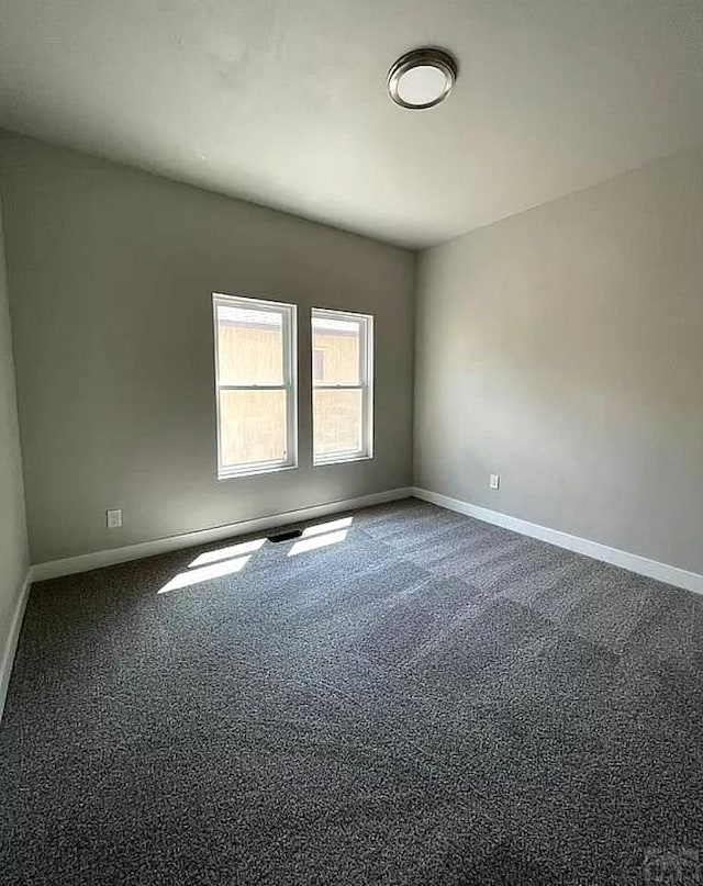 unfurnished room with baseboards