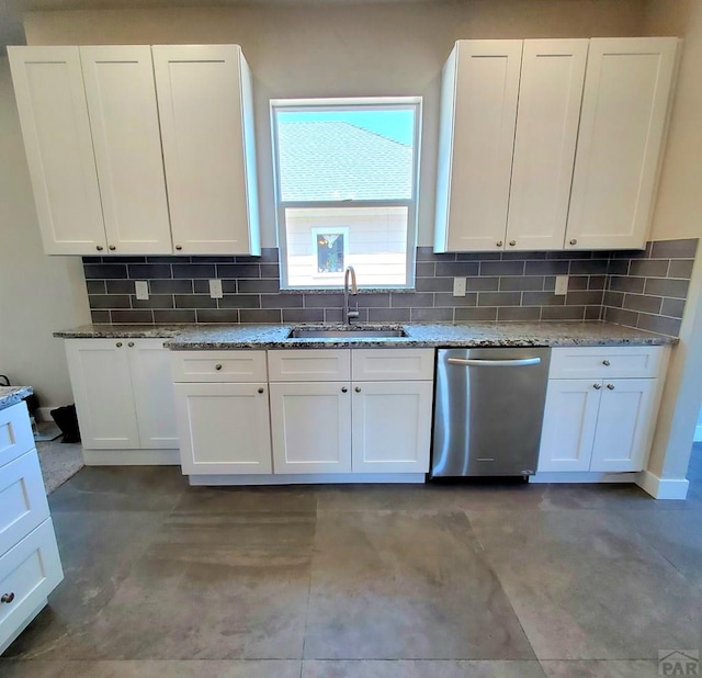 kitchen featuring stainless steel dishwasher, a sink, and white cabinets