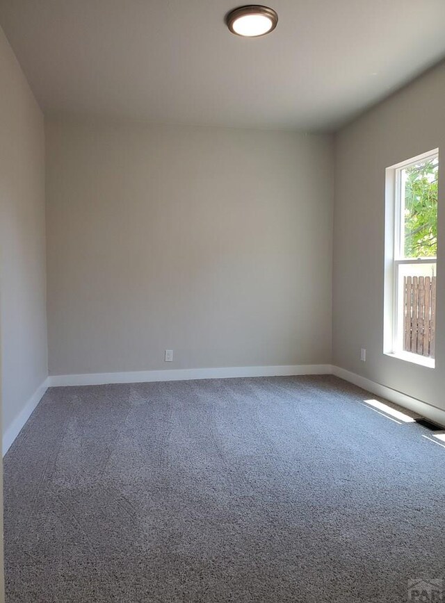 carpeted empty room with baseboards