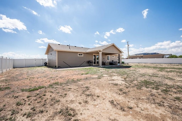 rear view of property featuring a patio, a fenced backyard, and board and batten siding