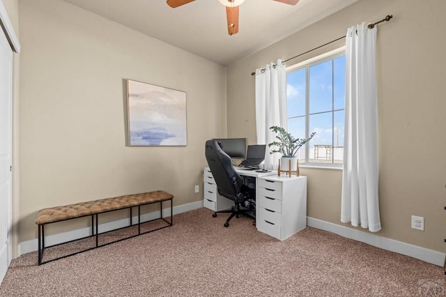 carpeted office with ceiling fan and baseboards