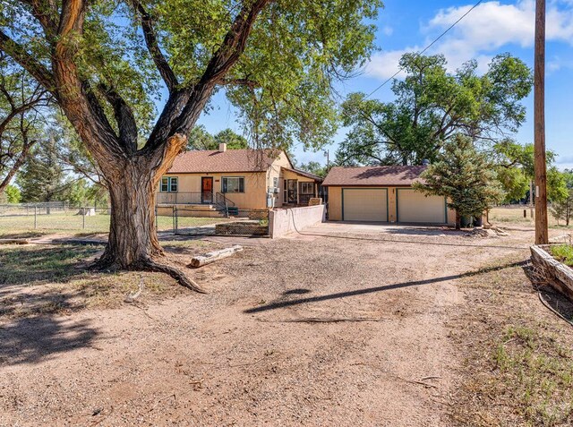 1404 Martin Ln, Avondale, CO 81025 - bungalow-style house with fence, dirt driveway, an attached garage, and an outdoor structure