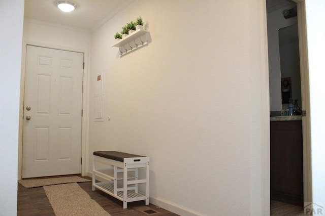 hallway featuring ornamental molding, dark wood-type flooring, and baseboards