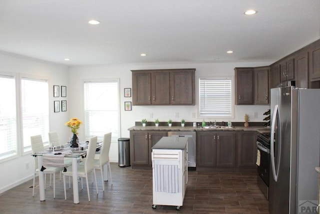 kitchen featuring appliances with stainless steel finishes, wood finish floors, dark countertops, and recessed lighting